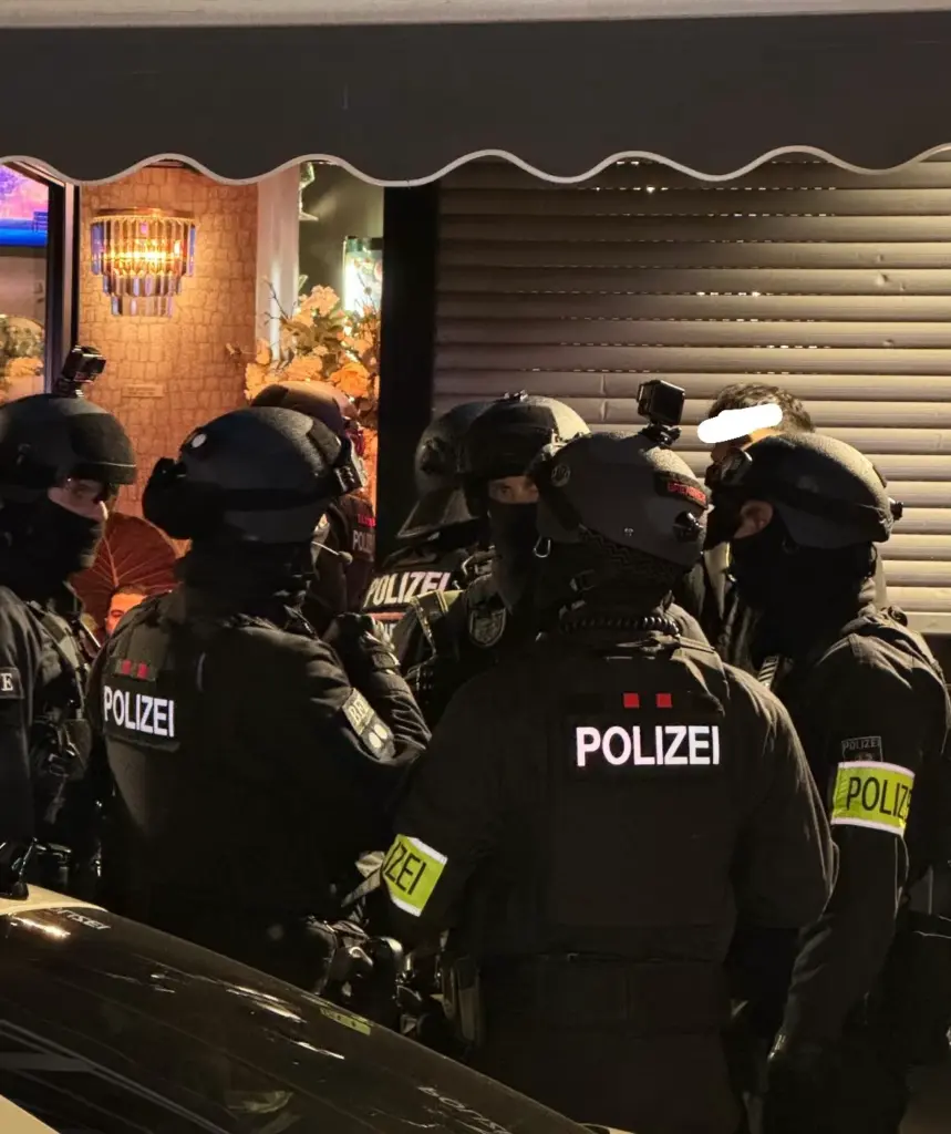Einsatzkräfte einer Spezialeinheit in Ausrüstung vor einem Objekt