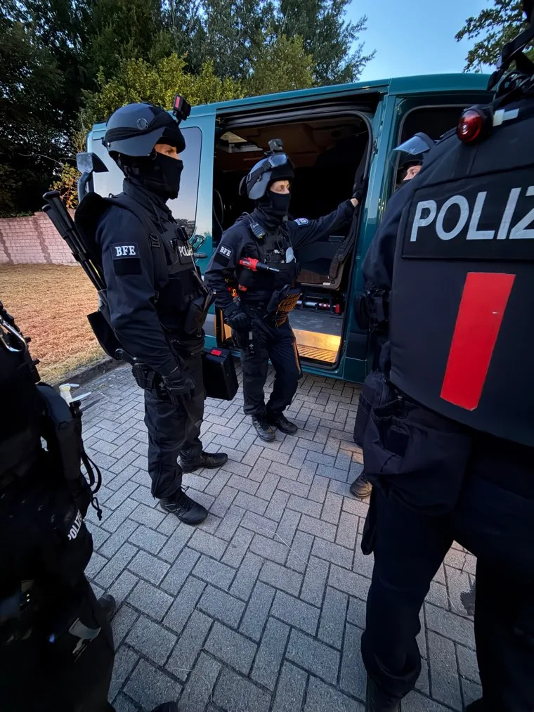 Zwei Einsatzkräfte im Gespräch an einem Dienstfahrzeug